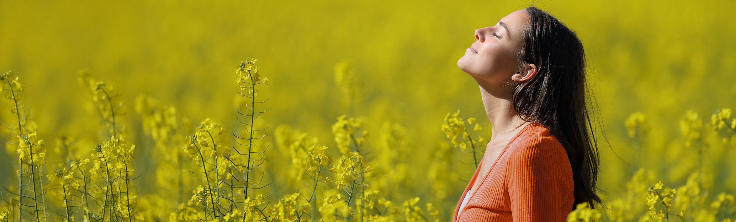 An adult smiling and looking away from the camera.